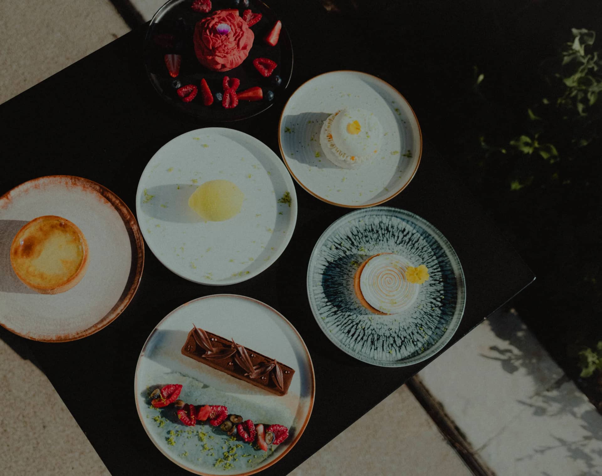 Plusieurs desserts du chef pâtissier dressés sur une table en terrasse